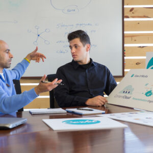 IMS Student Sam Huber Internship at Cerkl Two men sit in an office environment discussing a brand's logo.