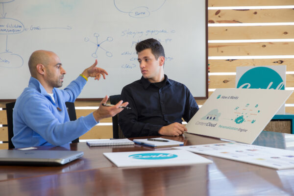 IMS Student Sam Huber Internship at Cerkl Two men sit in an office environment discussing a brand's logo.