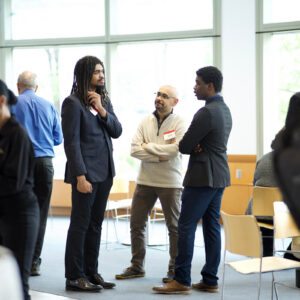 20250429_K9526_031 A group of individuals network and talk at an event.