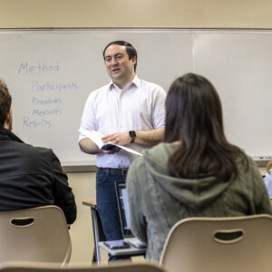 A man talks to a group of students in a classroom.